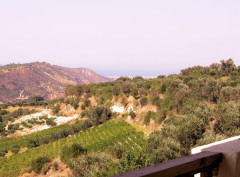 View from a balcony across the countryside towards the sea